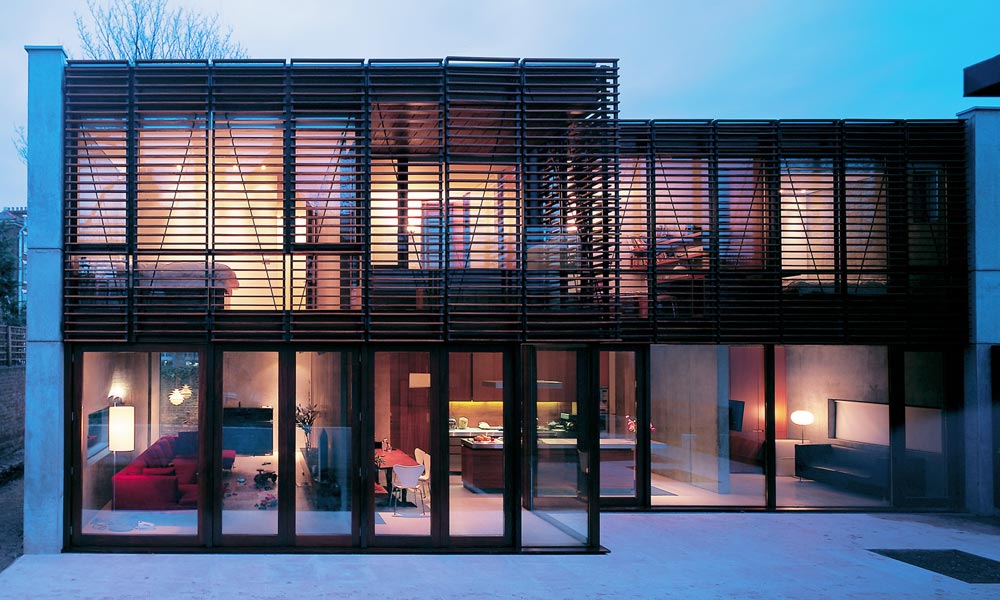 The new house on Aberdeen Lane is a courtyard house made up of simple textured volumes to create a new secluded family home. The starting point for the structure was the notion of two interlocking cubes of internally and externally exposed reinforced concrete, entirely open along one side. On the ground floor, the principal spaces open on to the main garden through storey height glazing, while the offsetting of the two cubes on plan leaves a small secluded garden space to the north-east, immediately outside the study. On the first floor the long landing corridor is top-lit, wide enough to be lined with shelving for the clients' extensive book collection. Windows of the upper-floor rooms facing the courtyard garden, part visible over the garden wall behind horizontal timber louvres. We provided all mechanical and electrical services including soil waste and ventilation, water, heating and lighting design.