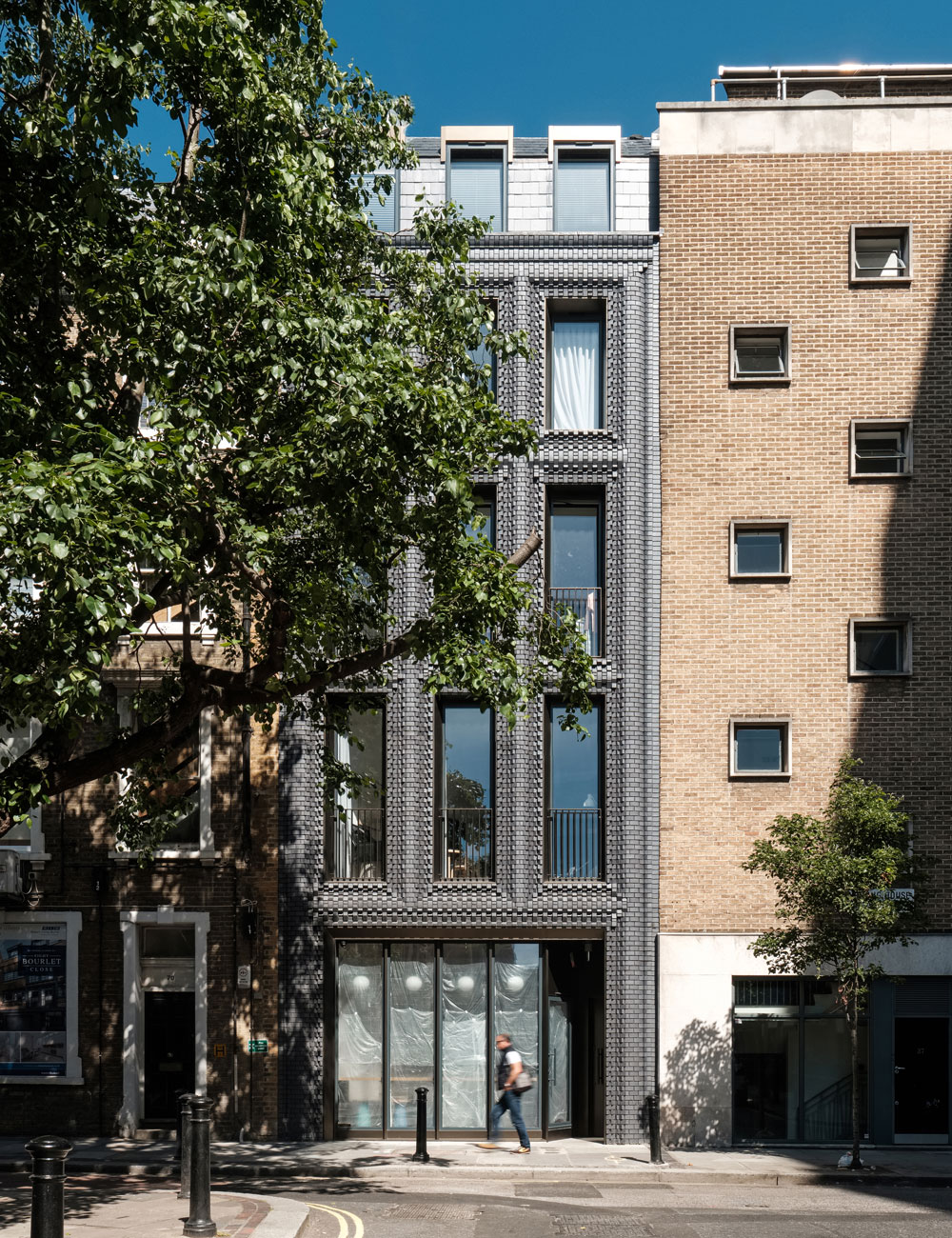 Prior to construction, the facade was modelled extensively to ensure the desired arrangement could be attained structurally. 5,000 Staffordshire blue bricks were set into 14 hand-crafted steel moulds and fired in oxidation to create 44 bespoke brick designs. A one-to-one template was then used on site to set out the location of each brick during construction. At the rear, the building is set out as a series of stacked boxes of varying form and size. Each floor is shallower than the last with the deepest floorplan at the bottom and the smallest at the top. Within this stepped form sits a series of deep light wells and skylights that track daylight into the centre and edges of the building, creating internal patios on the lowest floors and light wells on others. We provided all mechanical, electrical and drainage services for the project.