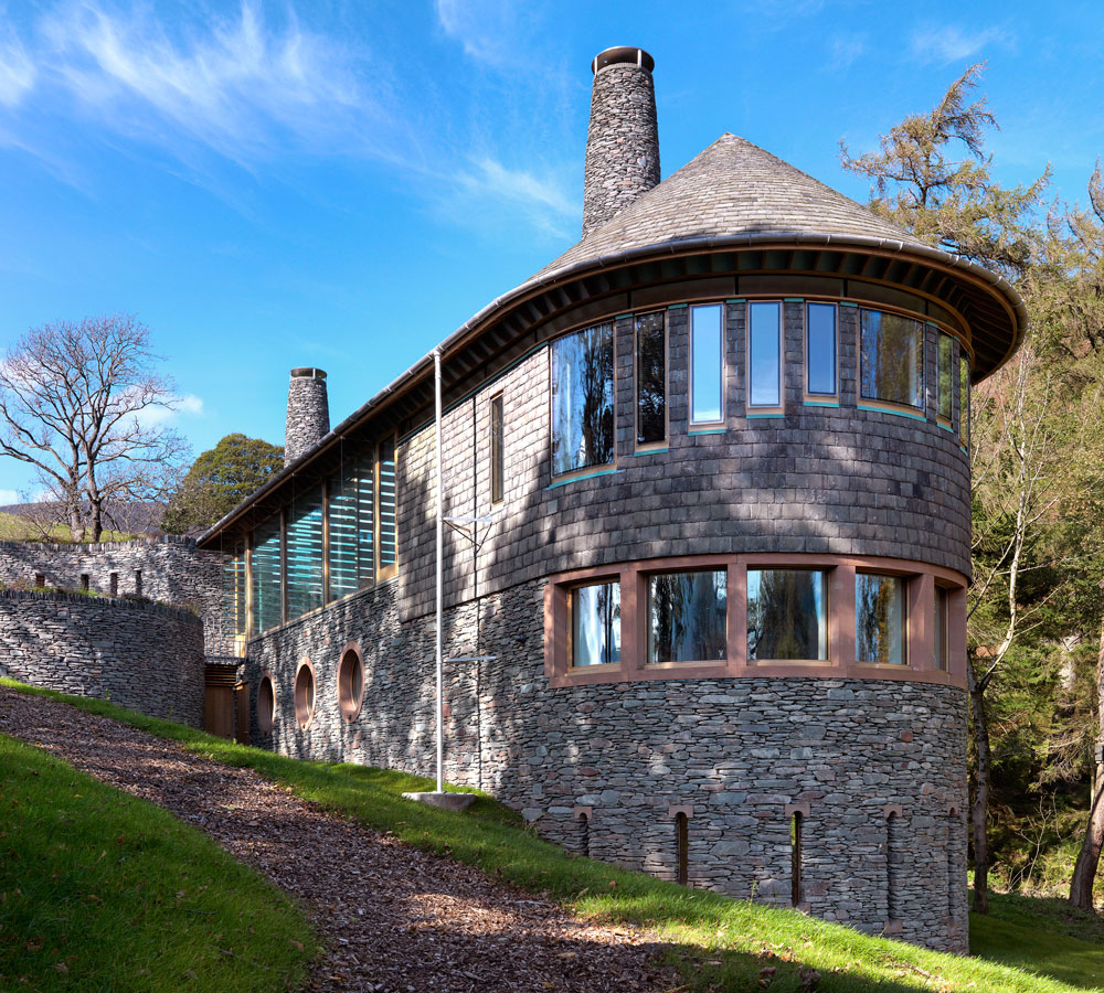 Rigg Beck is a new build, five-bedroom family dwelling within the Lake District National Park. The house has been designed to make the most of the open views of the fells, running perpendicular to the contours of the site. The principle materials are all sourced locally with Burlington slate cladding the dry-stone walling on the lower floors and Westmorland slate for the upper floor and roof.